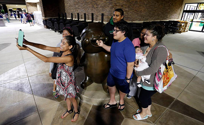 Les fans de Buc-ee prennent une photo avec la statue du castor