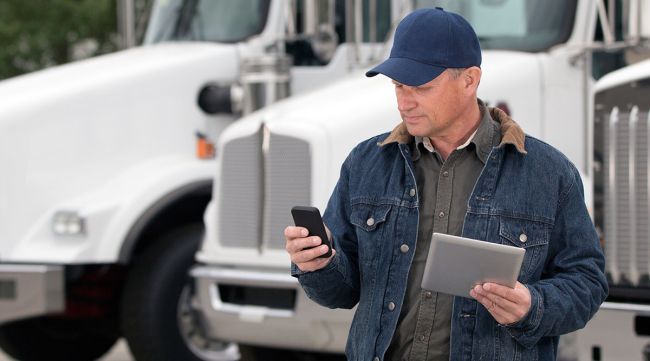 Chauffeur de camion sur téléphone, tablette